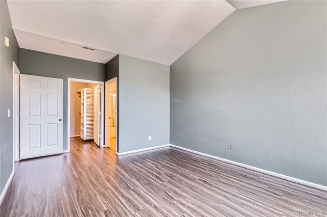 14251 E 1st Dr Unit 305, Aurora, CO 80011 - unfurnished bedroom with wood finished floors, vaulted ceiling, and a walk in closet