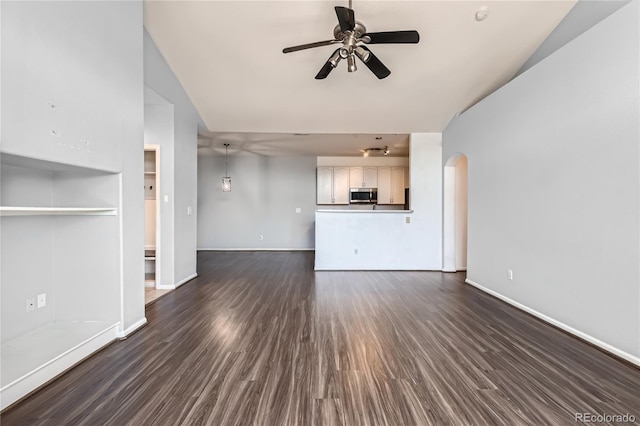 14251 E 1st Dr Unit 305, Aurora, CO 80011 - unfurnished living room with a ceiling fan, dark wood-style floors, arched walkways, and vaulted ceiling