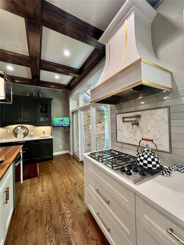 kitchen featuring beamed ceiling, dark hardwood / wood-style flooring, decorative backsplash, coffered ceiling, and custom range hood