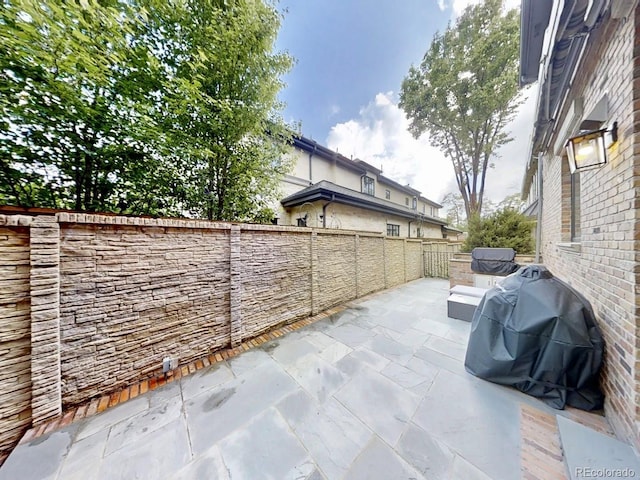 view of patio featuring area for grilling and fence