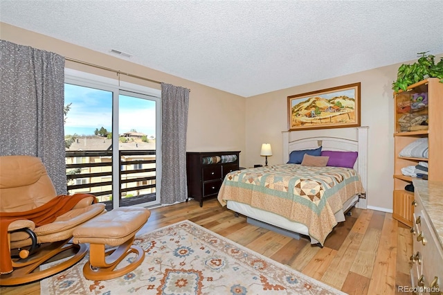 2242 Stepping Stones Way, Colorado Springs, CO 80904 - bedroom with light wood-style floors and a textured ceiling