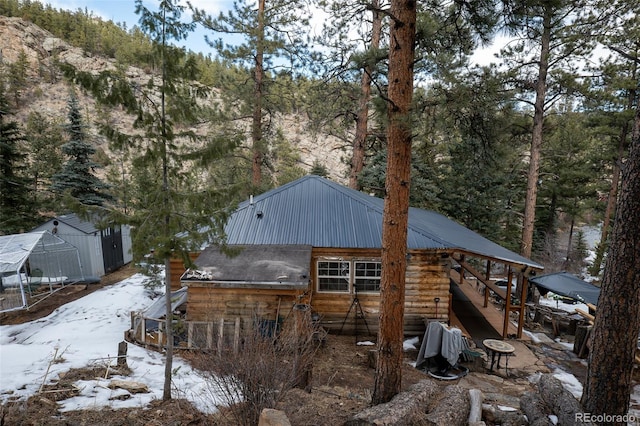 snow covered structure featuring an outbuilding