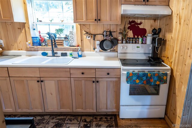 kitchen with wooden walls, a sink, white electric range oven, and under cabinet range hood