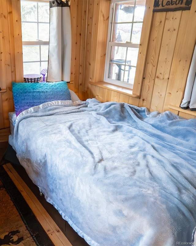 bedroom featuring wooden walls