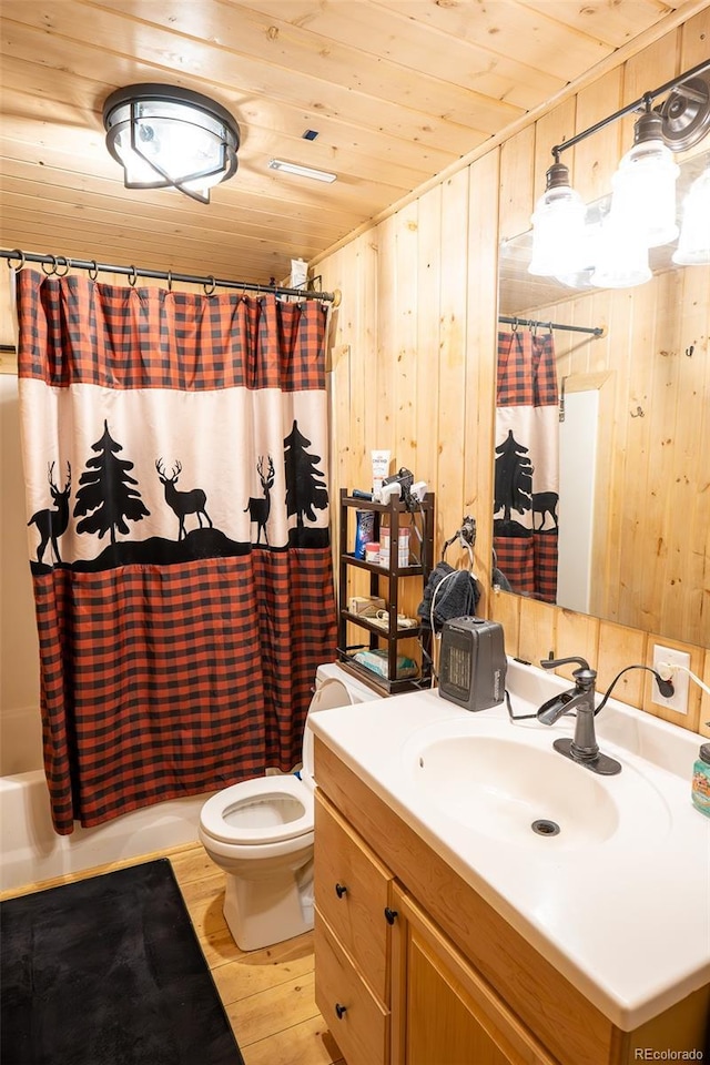 full bathroom featuring wooden walls, toilet, wooden ceiling, wood finished floors, and vanity