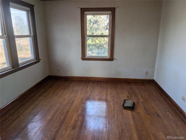 unfurnished room with dark hardwood / wood-style flooring