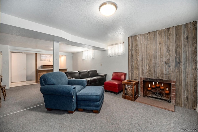 carpeted living room with a brick fireplace, a textured ceiling, and wood walls