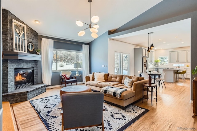 living room featuring lofted ceiling, a wealth of natural light, and light hardwood / wood-style flooring