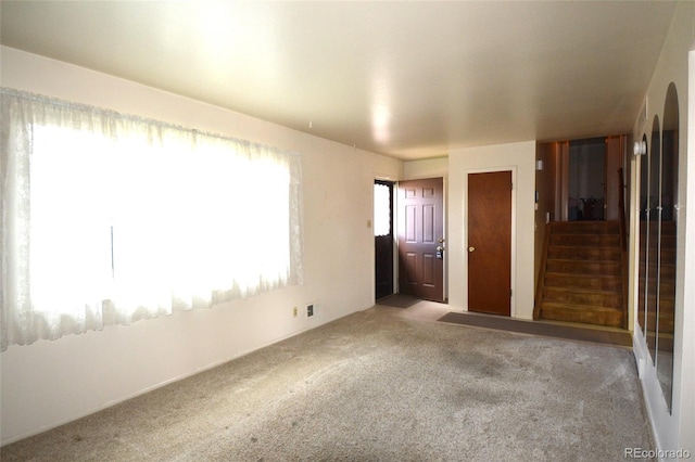 empty room featuring carpet flooring and stairs