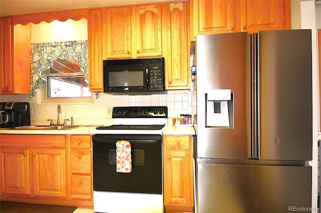 kitchen featuring stainless steel refrigerator with ice dispenser, black microwave, electric range oven, light countertops, and a sink