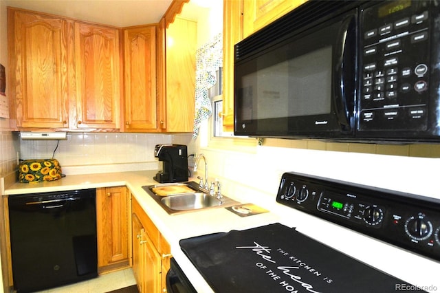 kitchen with backsplash, a sink, black appliances, and light countertops