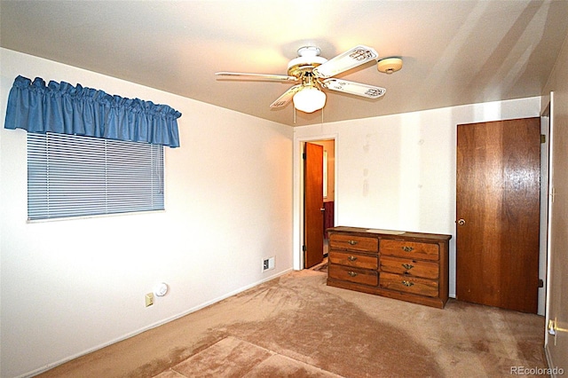 unfurnished bedroom featuring baseboards, carpet flooring, and a ceiling fan