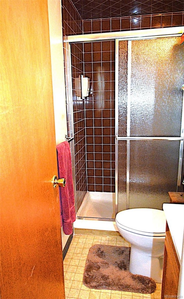 full bath with vanity, tile patterned floors, a stall shower, and toilet