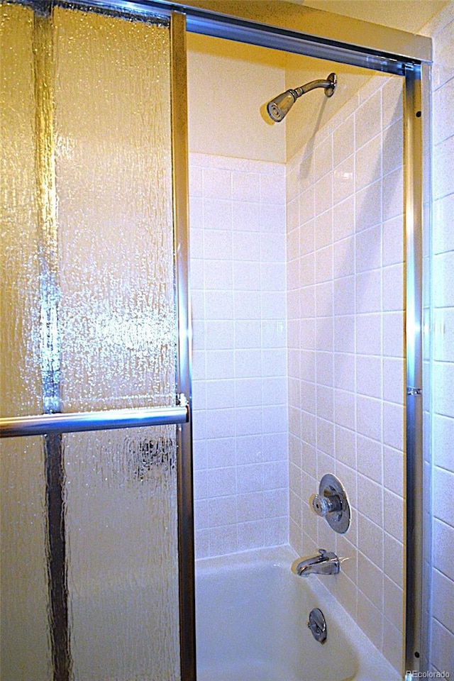 bathroom featuring combined bath / shower with glass door