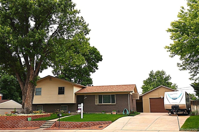 11823 Williams Way, Northglenn, CO 80233 - split level home featuring an outdoor structure, a detached garage, a front yard, and brick siding