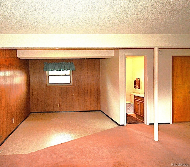 11823 Williams Way, Northglenn, CO 80233 - unfurnished bedroom with carpet floors, a textured ceiling, wooden walls, and baseboards