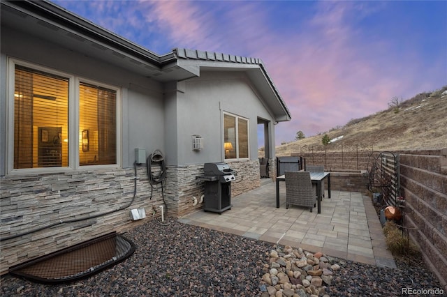 patio terrace at dusk featuring area for grilling