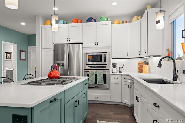 kitchen featuring stainless steel appliances, sink, white cabinetry, hanging light fixtures, and green cabinets