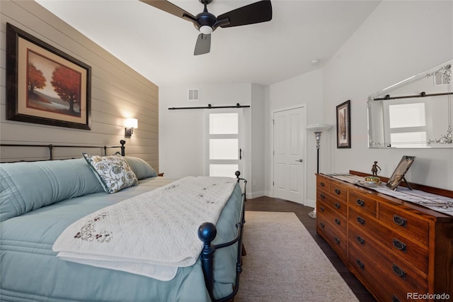 bedroom with ceiling fan and wooden walls