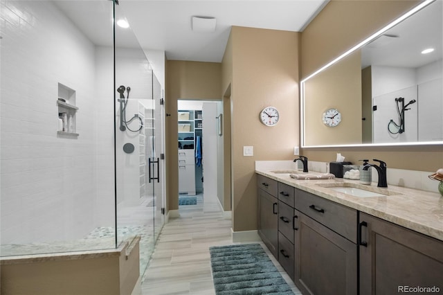 bathroom featuring tiled shower and vanity