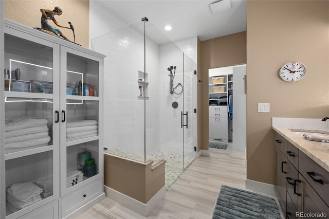 bathroom featuring wood-type flooring, vanity, and an enclosed shower