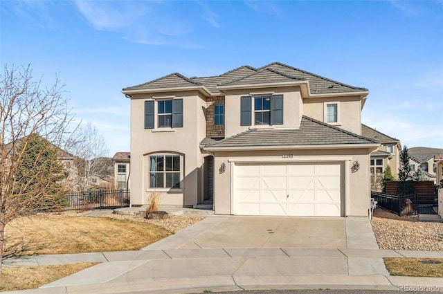 traditional-style home with stucco siding, concrete driveway, a garage, and fence