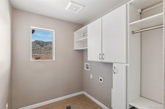 washroom with electric dryer hookup, washer hookup, cabinet space, light tile patterned flooring, and baseboards