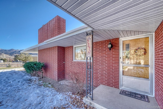 snow covered property entrance featuring a mountain view