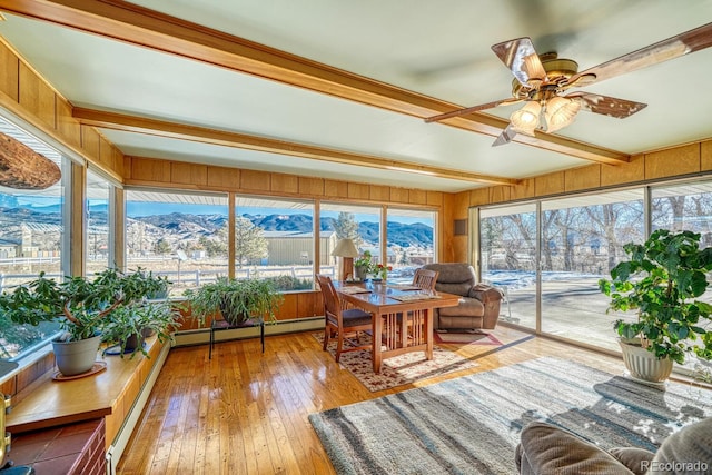 sunroom with a mountain view, beam ceiling, baseboard heating, and ceiling fan