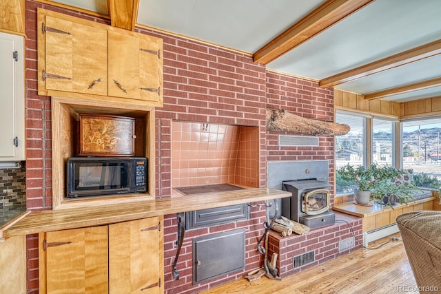 kitchen with beam ceiling, butcher block counters, baseboard heating, and light wood-type flooring