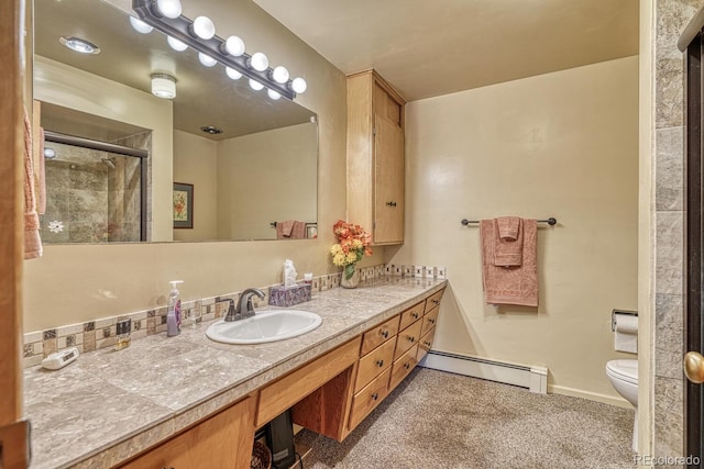 bathroom featuring toilet, vanity, a shower with door, and a baseboard heating unit