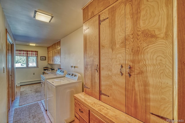 clothes washing area featuring washer and clothes dryer, cabinets, light wood-type flooring, and a baseboard heating unit