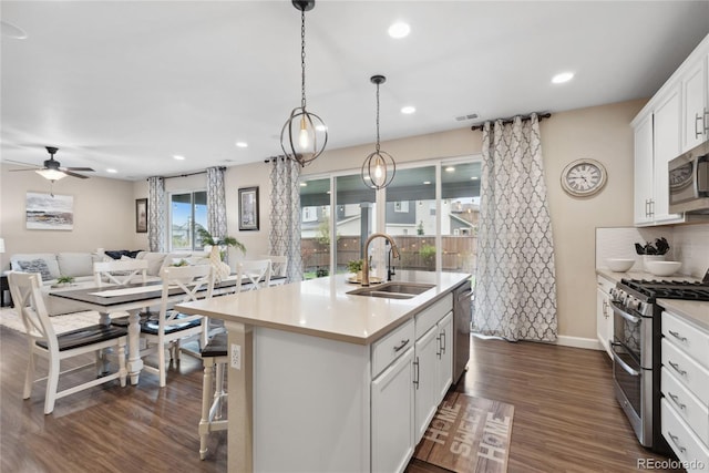 16400 Alberta Dr, Parker, CO 80134 - kitchen with appliances with stainless steel finishes, a sink, open floor plan, ceiling fan, and a center island with sink