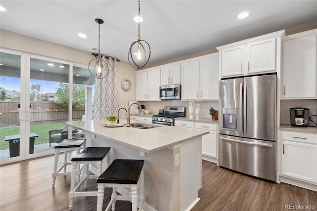 16400 Alberta Dr, Parker, CO 80134 - kitchen with appliances with stainless steel finishes, a sink, tasteful backsplash, white cabinetry, and recessed lighting