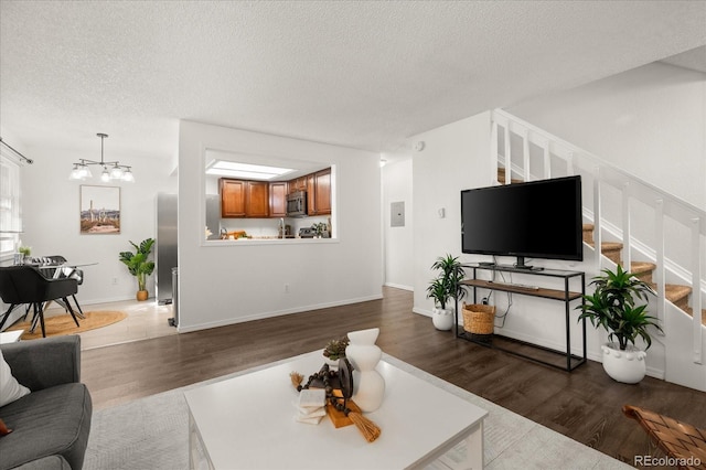 670 Winona Ct Unit 38, Denver, CO 80204 - living area featuring stairs, a textured ceiling, dark wood-style floors, and a chandelier