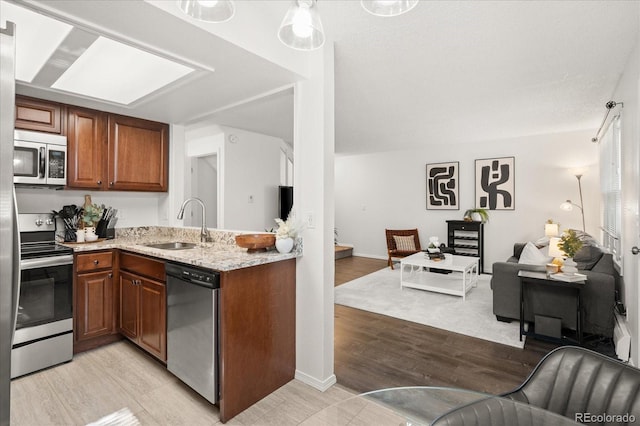 670 Winona Ct Unit 38, Denver, CO 80204 - kitchen featuring stainless steel appliances, a sink, light stone countertops, and brown cabinets