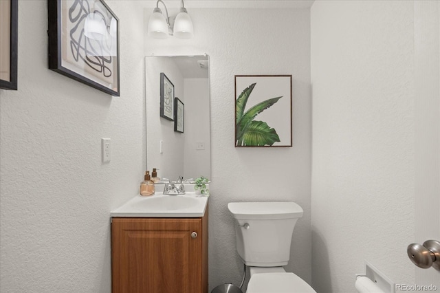 670 Winona Ct Unit 38, Denver, CO 80204 - half bathroom featuring vanity, toilet, and a textured wall