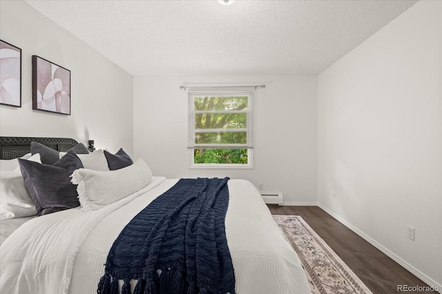 670 Winona Ct Unit 38, Denver, CO 80204 - bedroom featuring baseboard heating, dark wood-style flooring, a textured ceiling, and baseboards