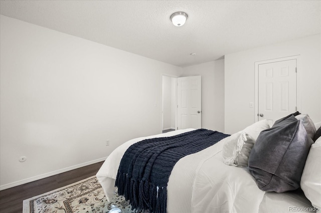 670 Winona Ct Unit 38, Denver, CO 80204 - bedroom featuring dark wood-type flooring, baseboards, and a textured ceiling
