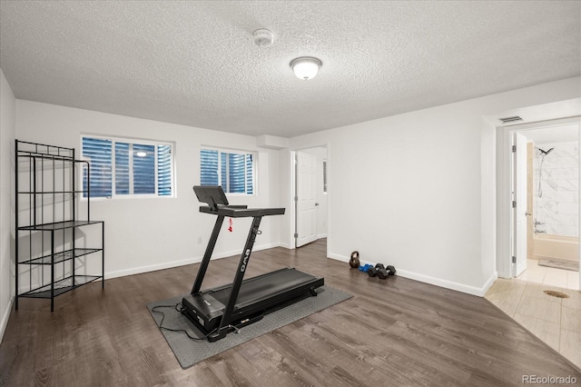 670 Winona Ct Unit 38, Denver, CO 80204 - workout room featuring wood finished floors, baseboards, and a textured ceiling