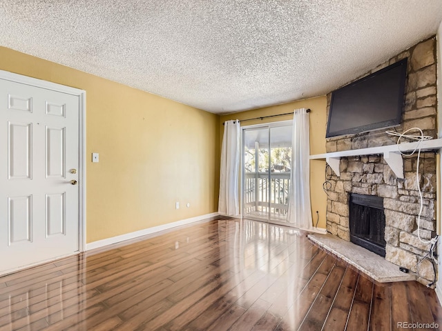 living room featuring hardwood / wood-style flooring, a fireplace, and a textured ceiling