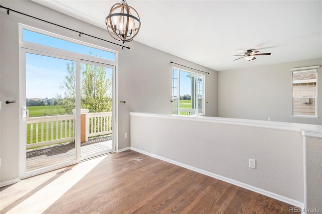 11748 Mill Valley St, Parker, CO 80138 - unfurnished dining area with baseboards, wood finished floors, a chandelier, and a ceiling fan
