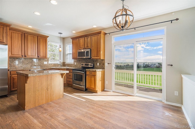 11748 Mill Valley St, Parker, CO 80138 - kitchen with appliances with stainless steel finishes, brown cabinets, a sink, light wood-style flooring, and recessed lighting