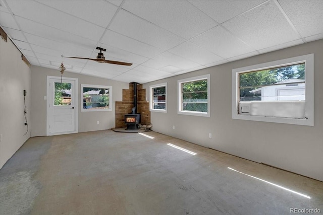 10 Juneau Pl, Longmont, CO 80504 - carpeted empty room featuring a wood stove, ceiling fan, and a paneled ceiling