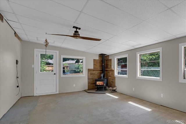 10 Juneau Pl, Longmont, CO 80504 - unfurnished living room featuring a ceiling fan, a wood stove, a paneled ceiling, and carpet flooring