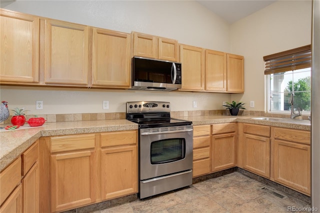 354 Willowick Cir, Highlands Ranch, CO 80129 - kitchen with stainless steel appliances, light brown cabinetry, a sink, tile countertops, and stone finish flooring