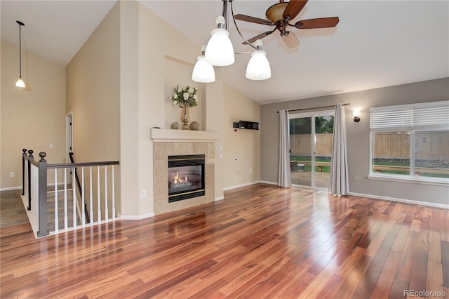 354 Willowick Cir, Highlands Ranch, CO 80129 - unfurnished living room with vaulted ceiling, wood finished floors, a ceiling fan, baseboards, and a tiled fireplace