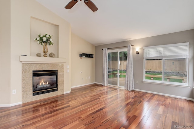 354 Willowick Cir, Highlands Ranch, CO 80129 - unfurnished living room featuring lofted ceiling, ceiling fan, wood finished floors, a tile fireplace, and baseboards