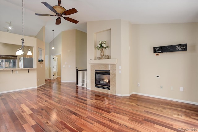 354 Willowick Cir, Highlands Ranch, CO 80129 - unfurnished living room with wood finished floors, ceiling fan, baseboards, high vaulted ceiling, and a glass covered fireplace