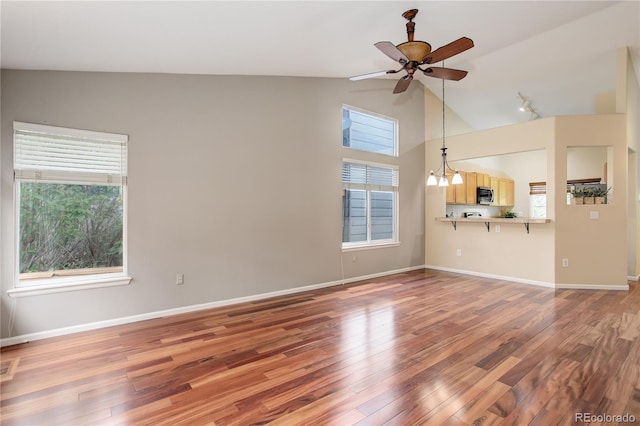 354 Willowick Cir, Highlands Ranch, CO 80129 - unfurnished living room featuring ceiling fan, wood finished floors, vaulted ceiling, and baseboards